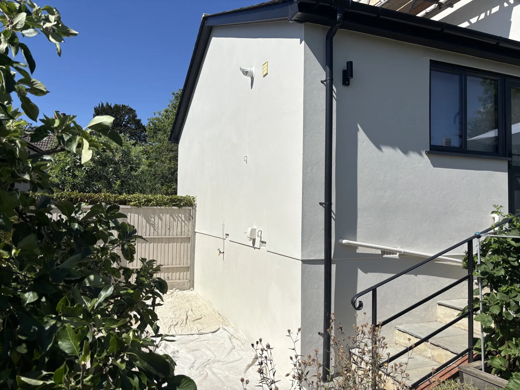 Close detail of the completed render finish on a corner of the house