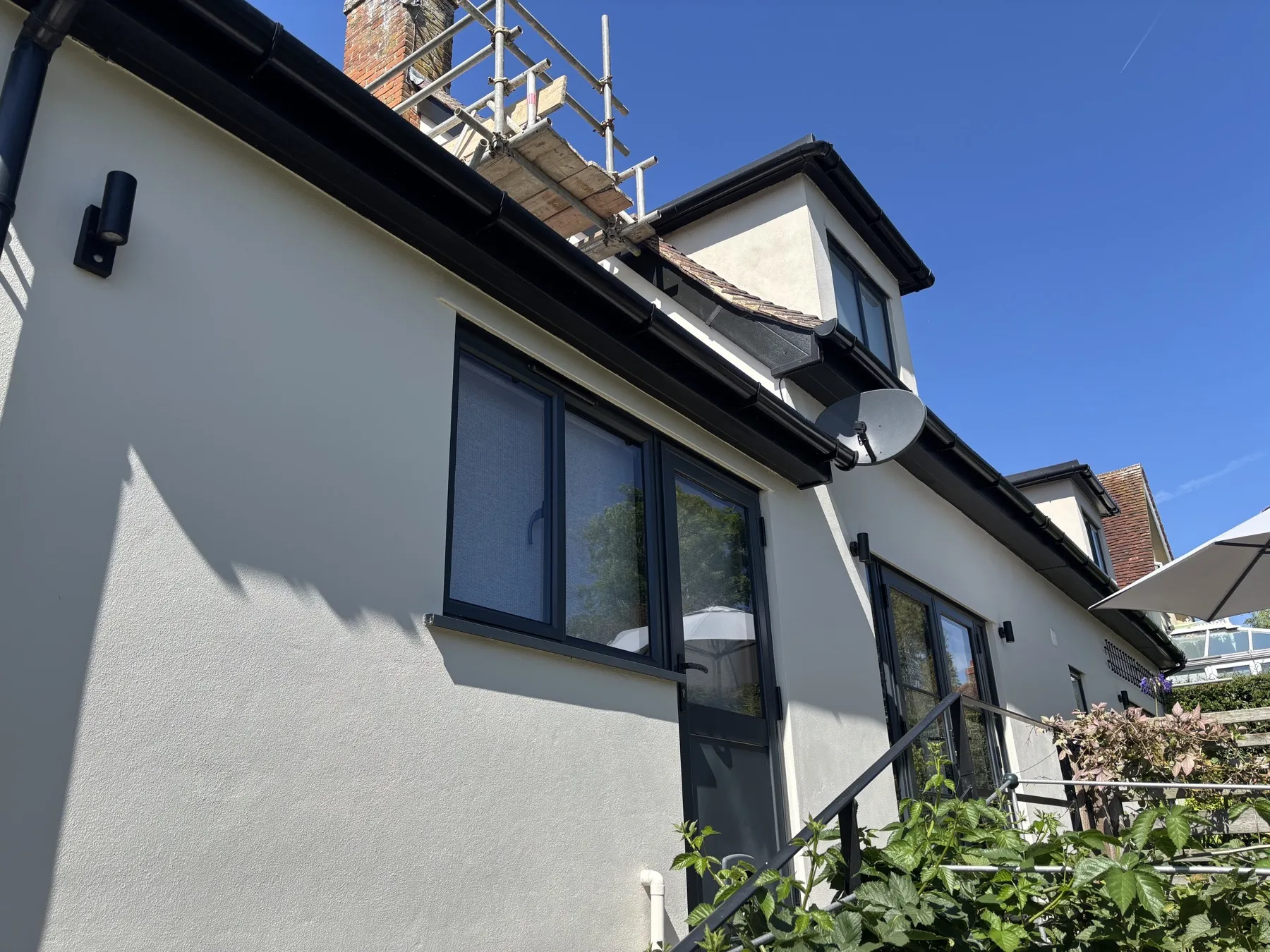Rear elevation with black bifold doors and dormer window after the render repaint