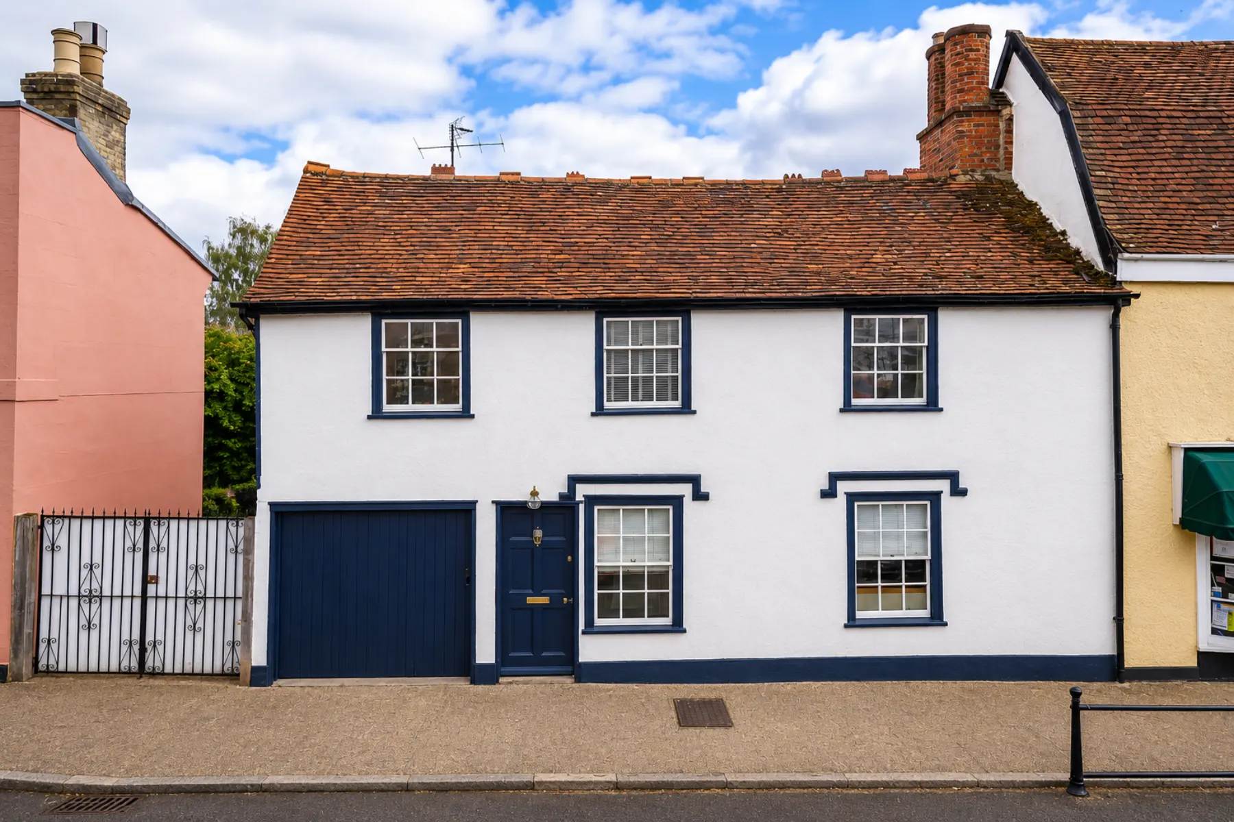 Painted front elevation of a Long Melford period property with white walls and dark blue trim