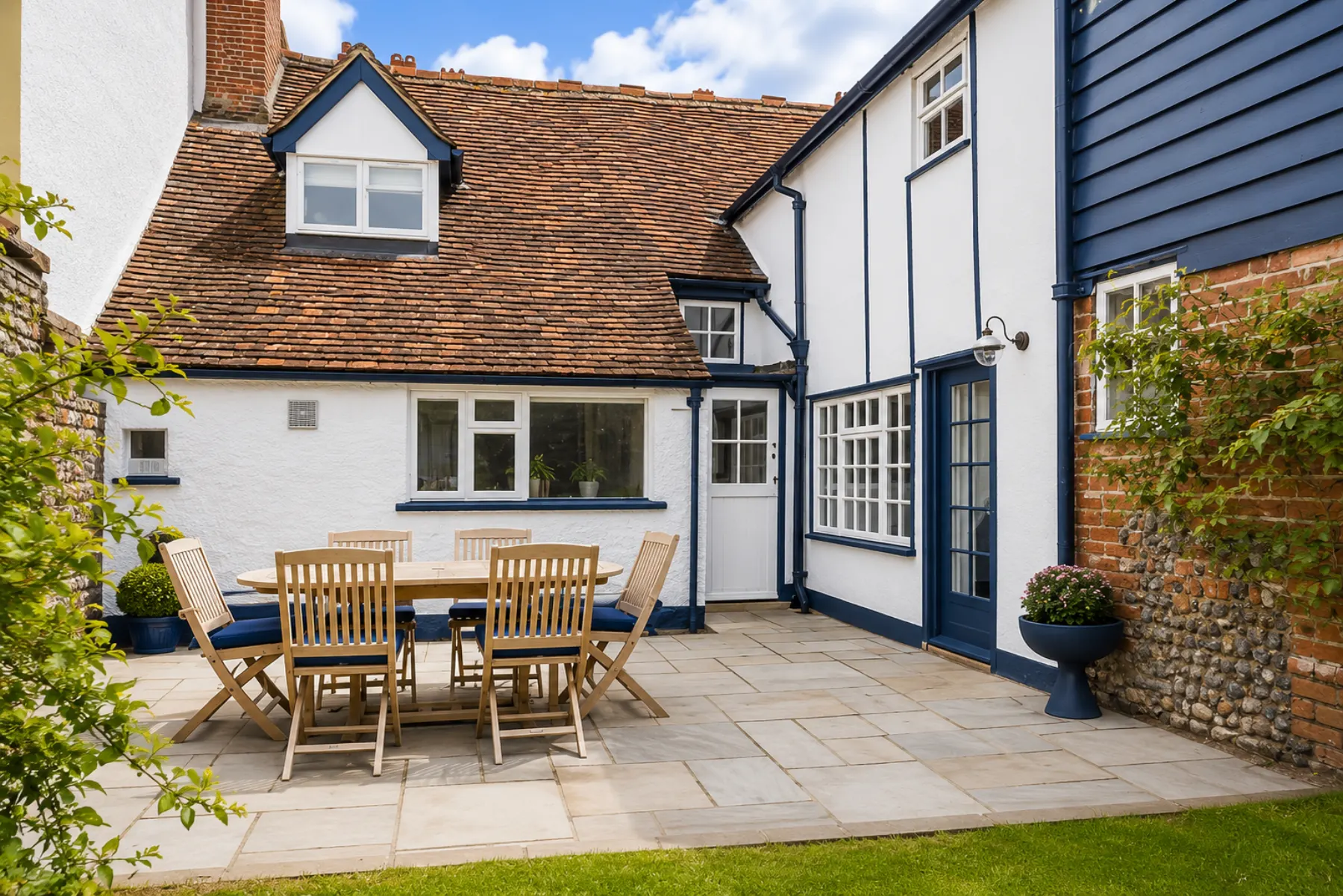 Rear courtyard of a Long Melford period property with painted white walls and blue exterior trim